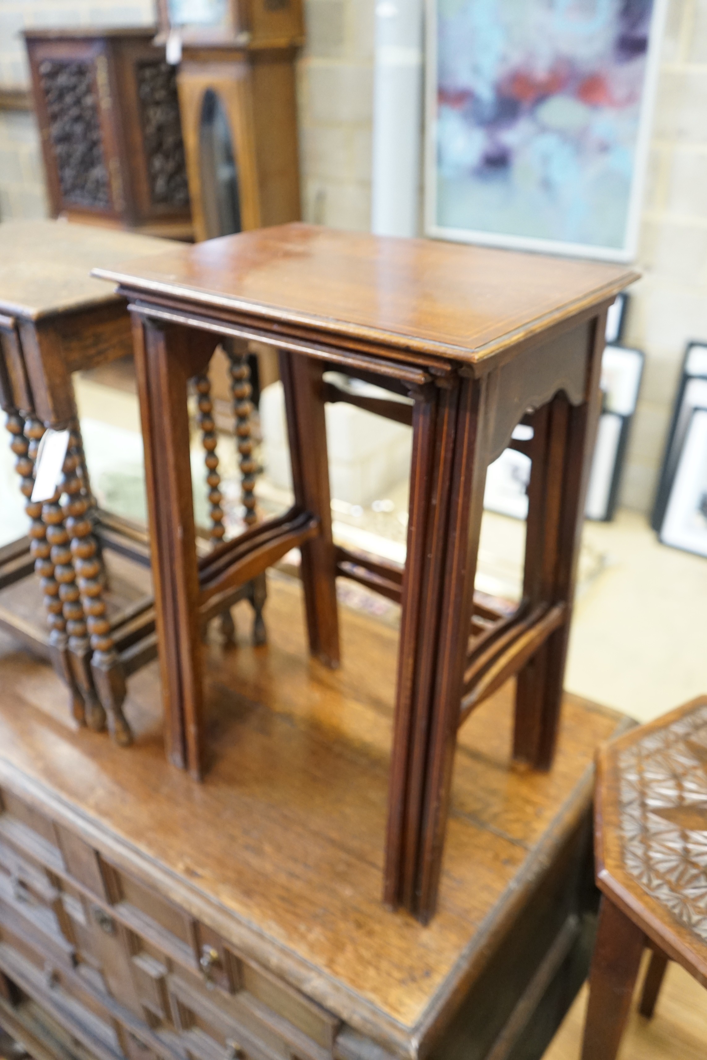 A nest of three Edwardian mahogany tea tables, height 61cm, a nest of three oak tea tables and an octagonal carved occasional table
